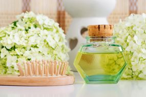 复古玻璃瓶用化妆油（按摩油，酊，输液，提取物），木发刷和白色霍滕西亚（八仙花属）花。芳香疗法，自创spa和草药概念。复制空间。