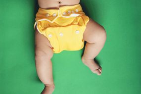 婴儿穿黄布尿布＂width=