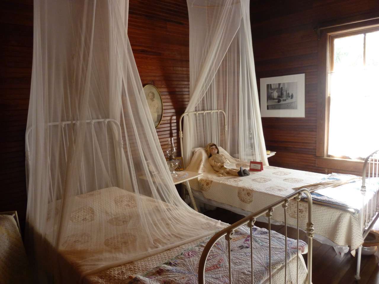 一个镶木板的房间和两个小床,两个网罩