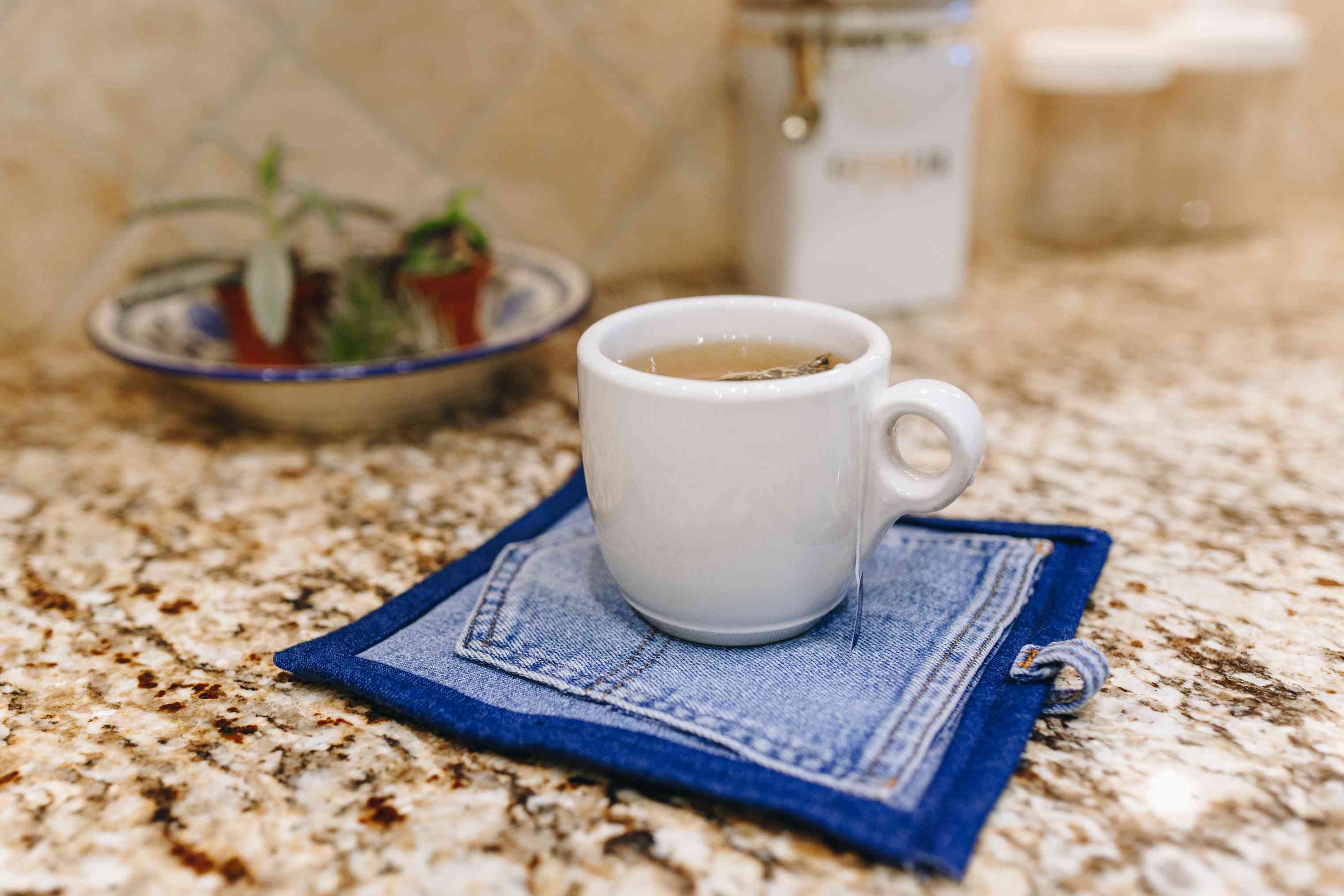 厨房里，一杯热茶放在升级改造的牛仔鸡尾酒餐巾纸上