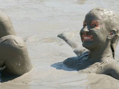 人躺在泥浴用泥土覆盖了她的脸和头发