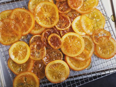在烤炉前将蜜饯柠檬和橘子片放在金属架上