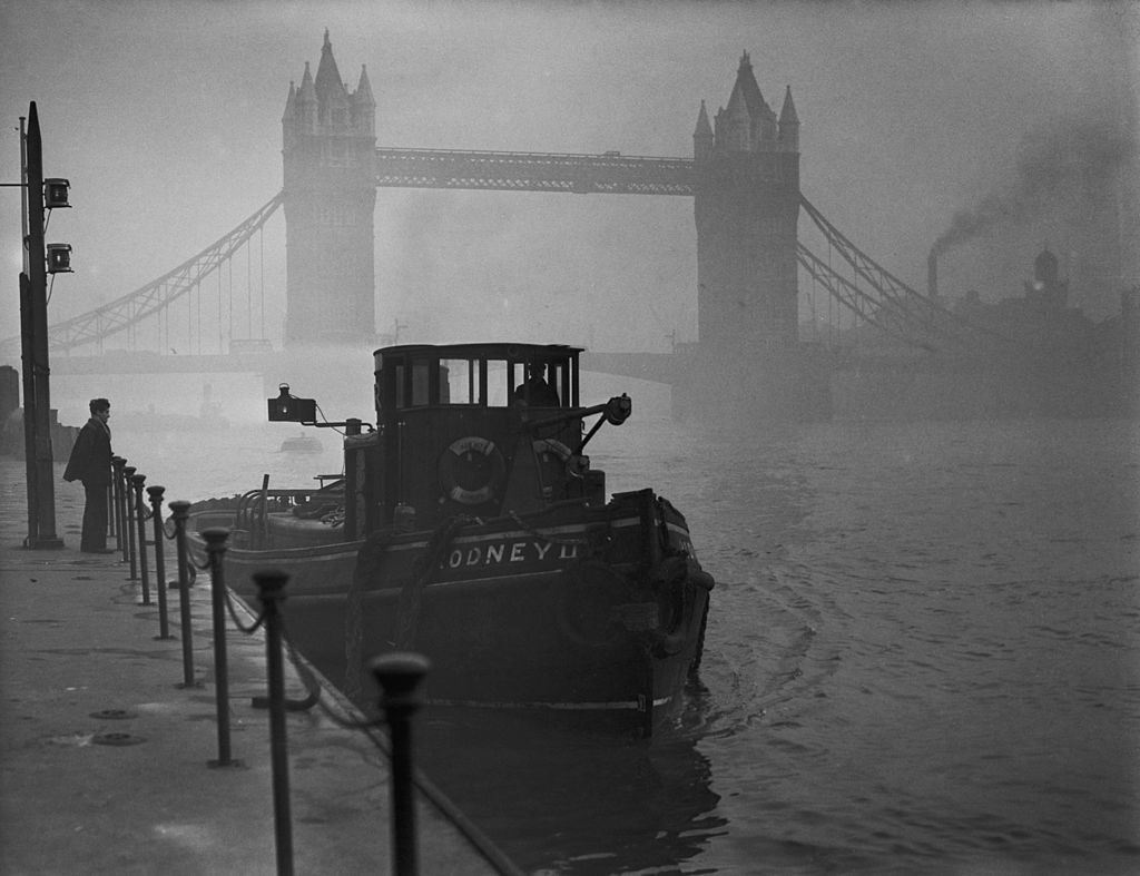 1952年，泰晤士河塔桥附近烟雾弥漫的一艘拖船。