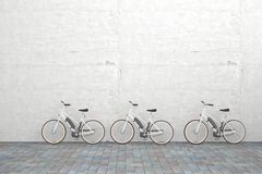 三辆停放的电动自行车在混凝土墙前
