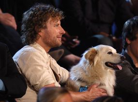 乡村歌手迪克斯·本特利在颁奖典礼上和狗狗杰克坐在一起。