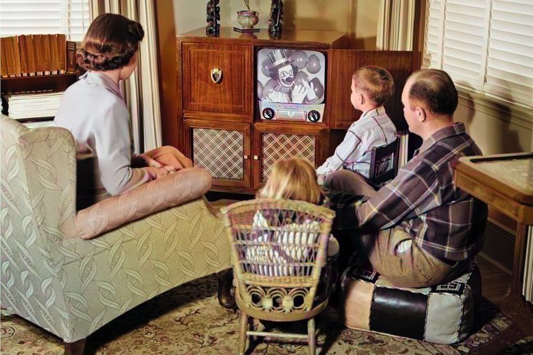一个四个家庭的复古般的图像，看着黑白电视。“class=