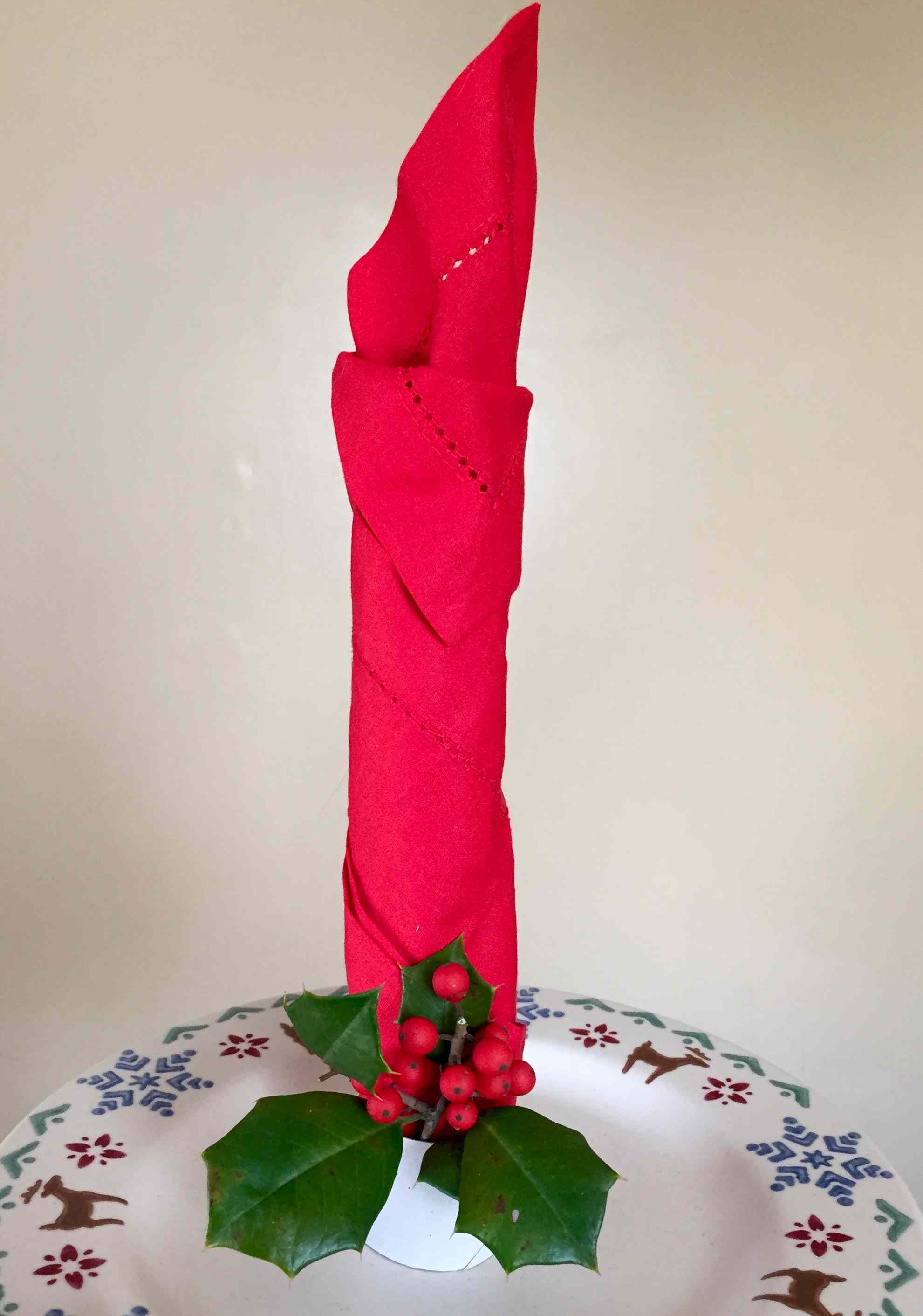 红色餐巾折叠成蜡烛形状