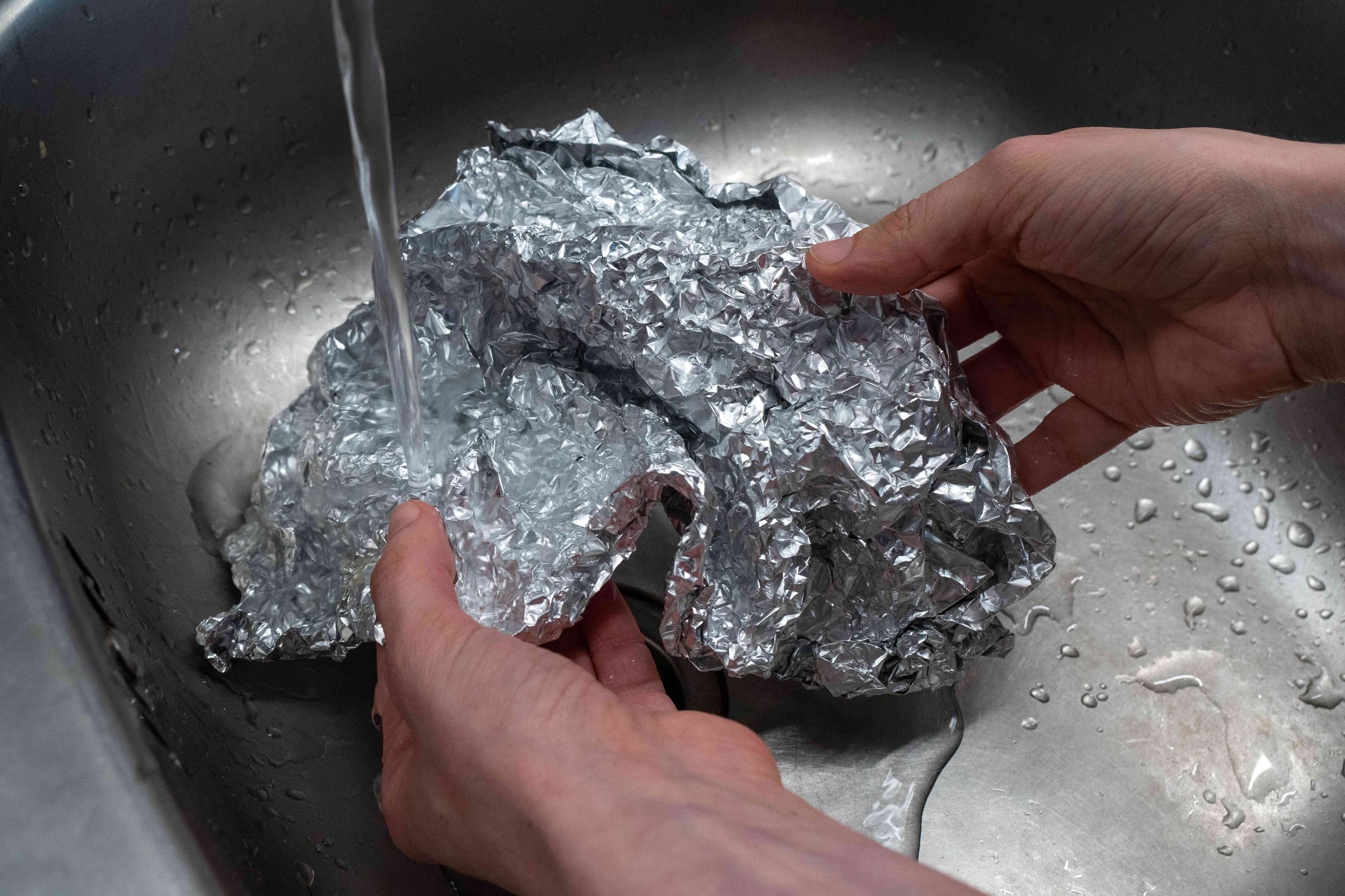 用手用水清洗钢水槽内用过的铝箔