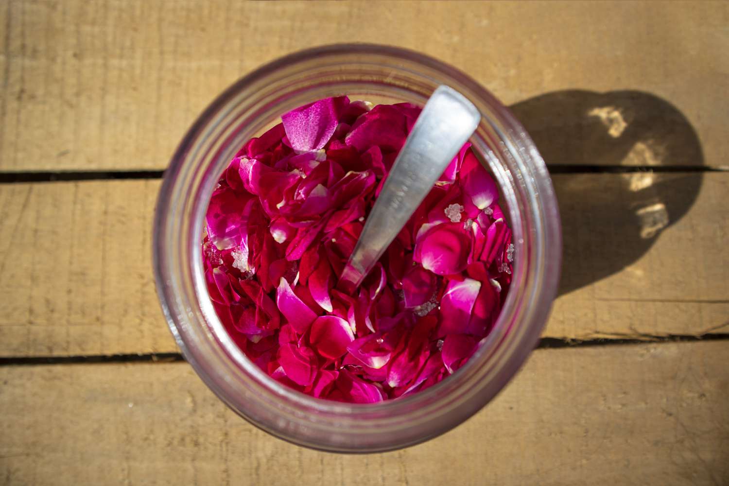 顶视图的玫瑰花瓣放在一个玻璃罐中添加糖的一个叫做Gulkand配方。”>
              </noscript>
             </div>
            </div>
            <figcaption id=