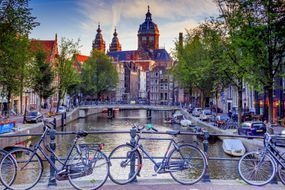 自行车在阿姆斯特丹运河大桥上休息”width=