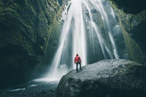 游客在岩石上欣赏Gljufrabui瀑布，冰岛