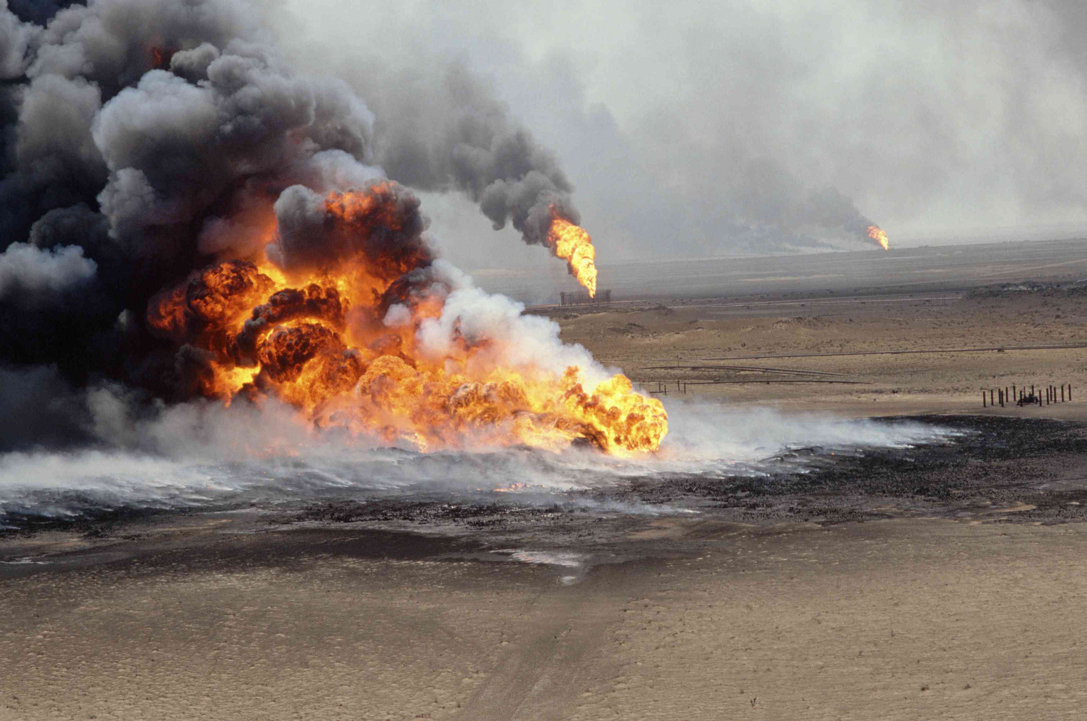 科威特正在燃烧的油田。图像显示的景观与3个火在前景和背景。