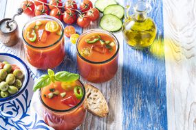 新鲜的彩色蔬菜西班牙凉菜汤配西红柿在阳光下的条纹桌子上