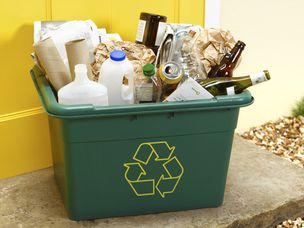 绿色回收箱外面的露台上装满了塑料和玻璃瓶