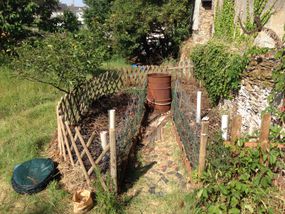 A keyhole garden nestled against a wall