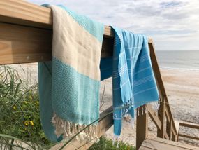 2条土耳其毛巾挂在海滩的栏杆上