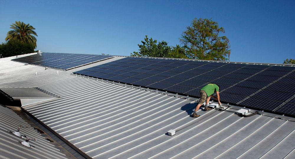 2009年，一名男子在佛罗里达州盖恩斯维尔的屋顶上安装太阳能电池板