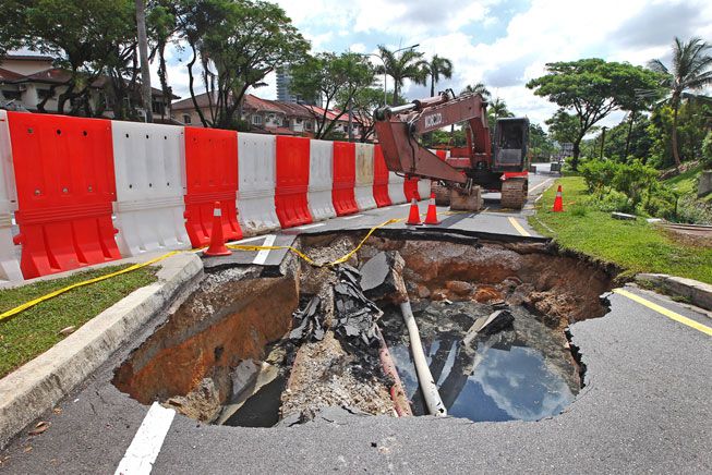 倾盆大雨后，一个巨大的污水坑吞下了交通信号灯并切断了吉隆坡的电源