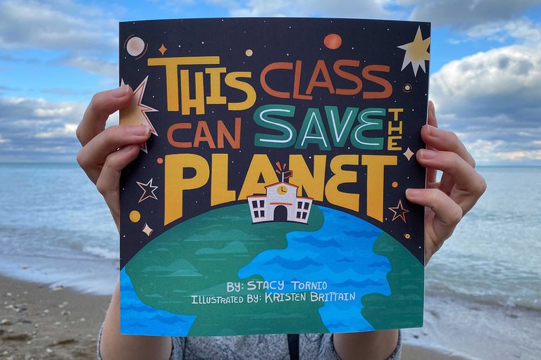 手里拿着一本彩色的书，书名是《这门课可以拯救地球》