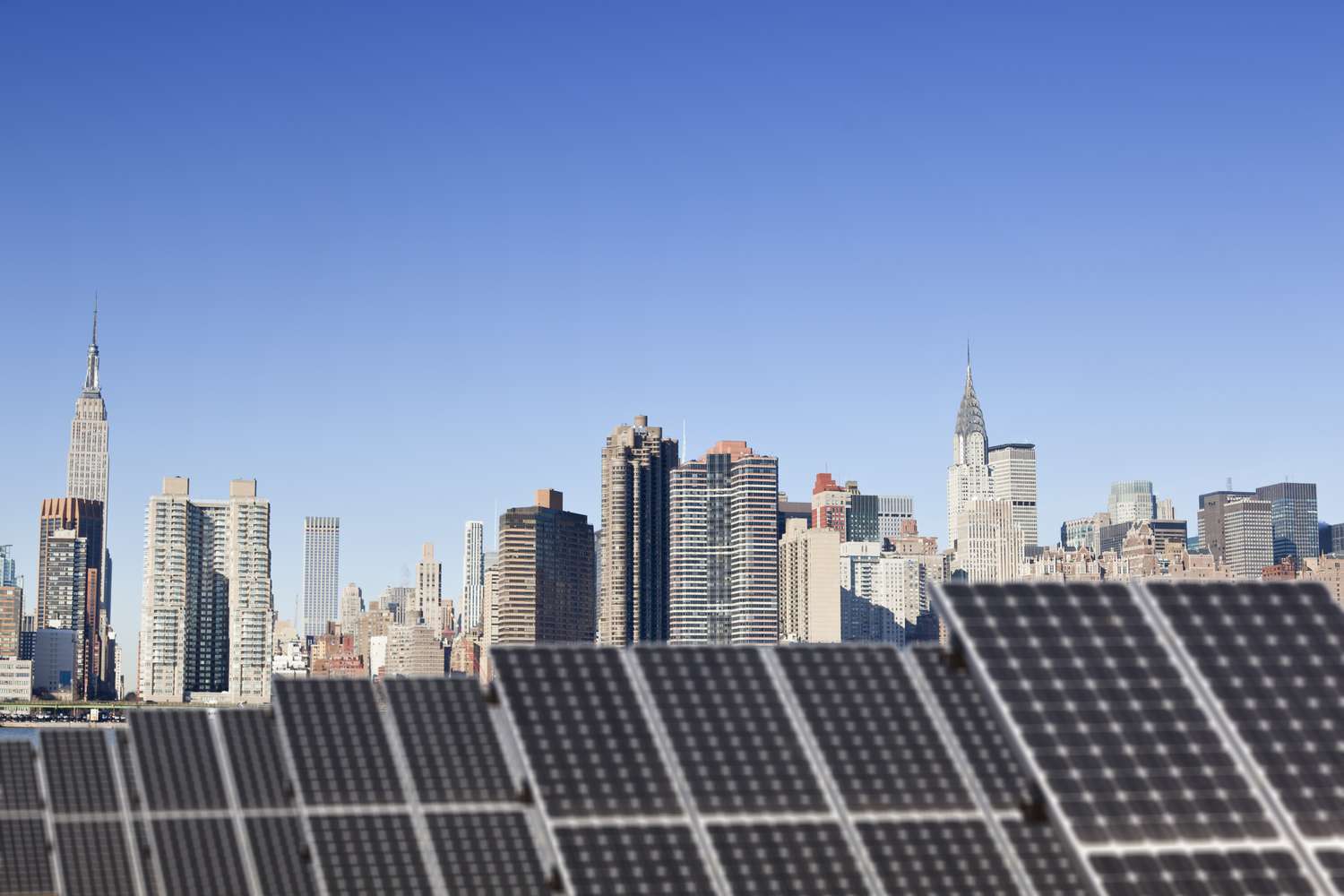 屋顶上的太阳能电池板，背景是纽约市。