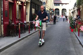 巴黎骑踏板车的老人