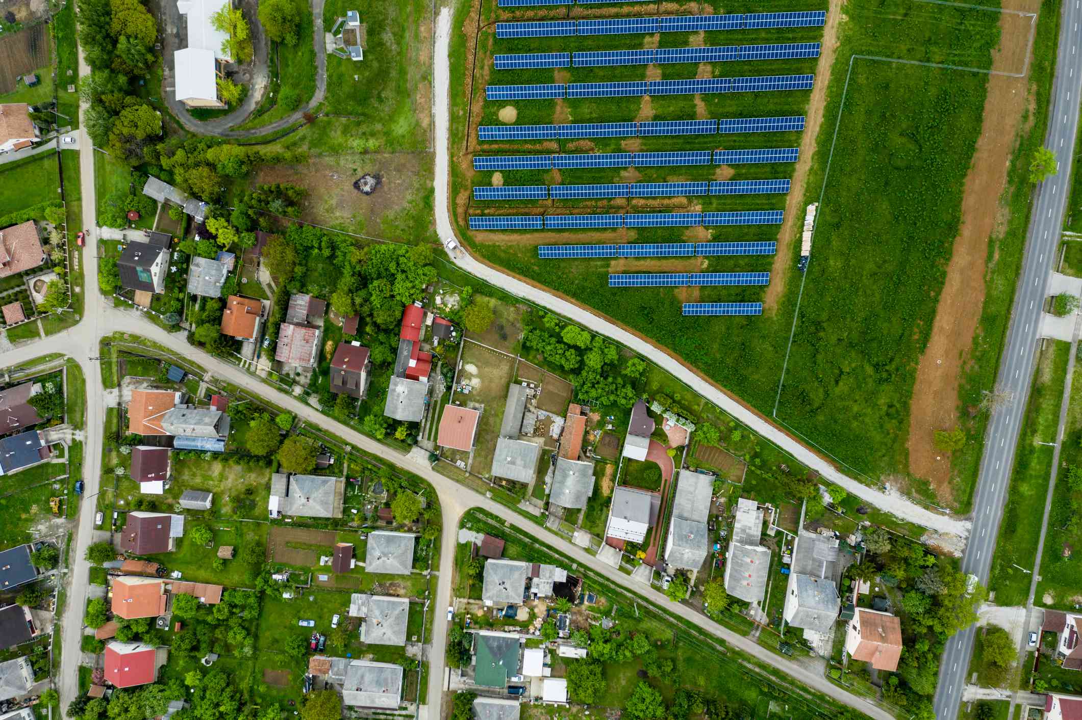 从鸟瞰图中可以看到居民区附近的太阳能电池板。＂width=