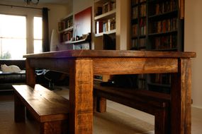 农家餐桌由可持续木材建造，背景是书架