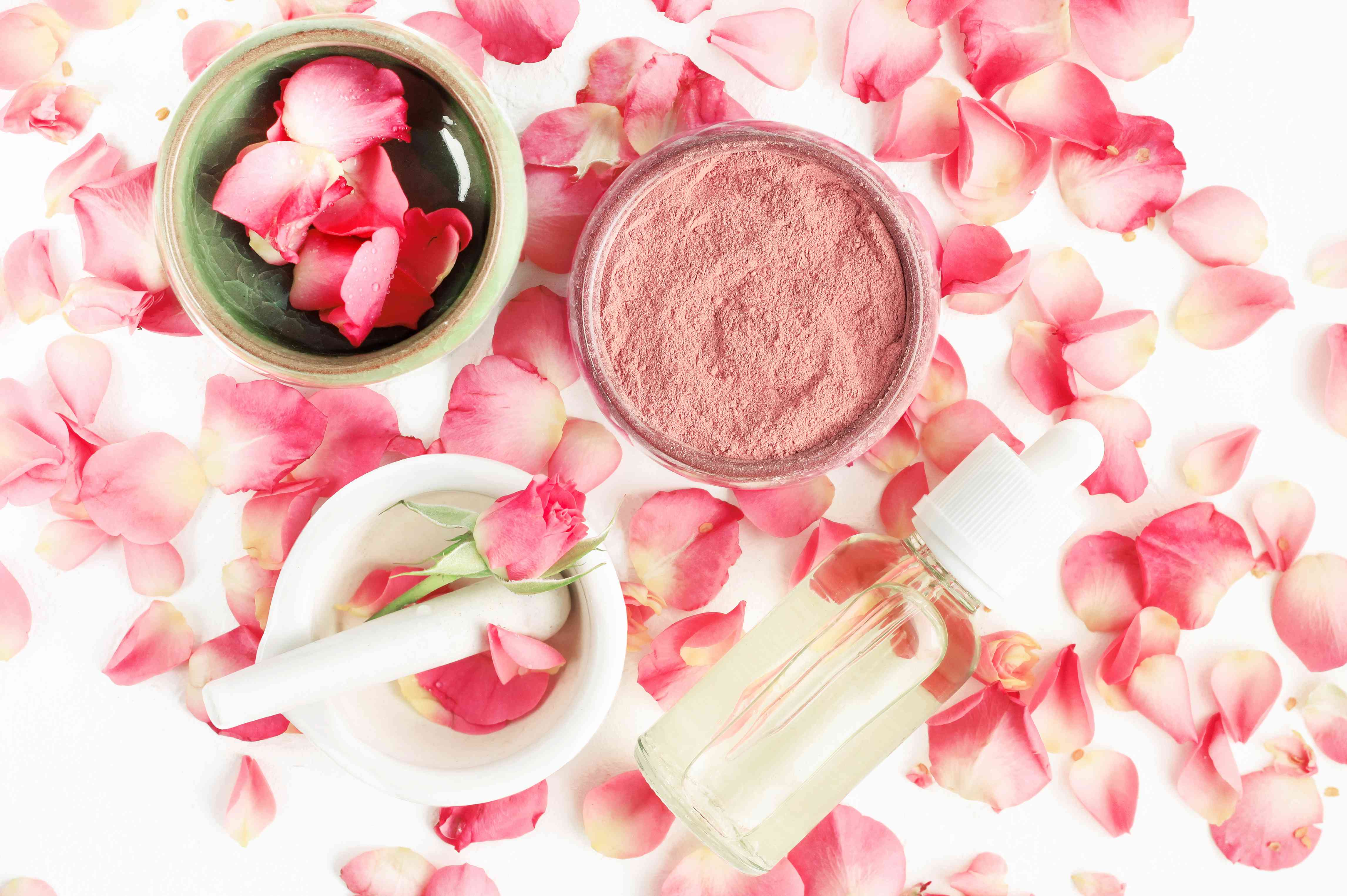 顶视图植物护肤品家水疗治疗粉色玫瑰花瓣和粘土面具