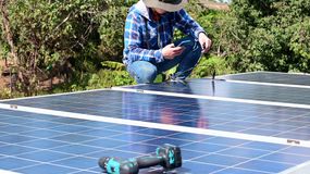 工人在安装太阳能电池板时使用手机的低截面