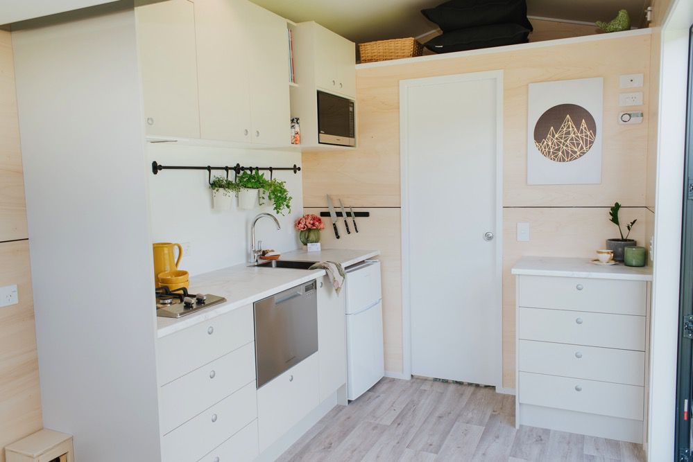 厨房视图显示柜台，水槽和橱柜，与门和抽屉柜相邻
