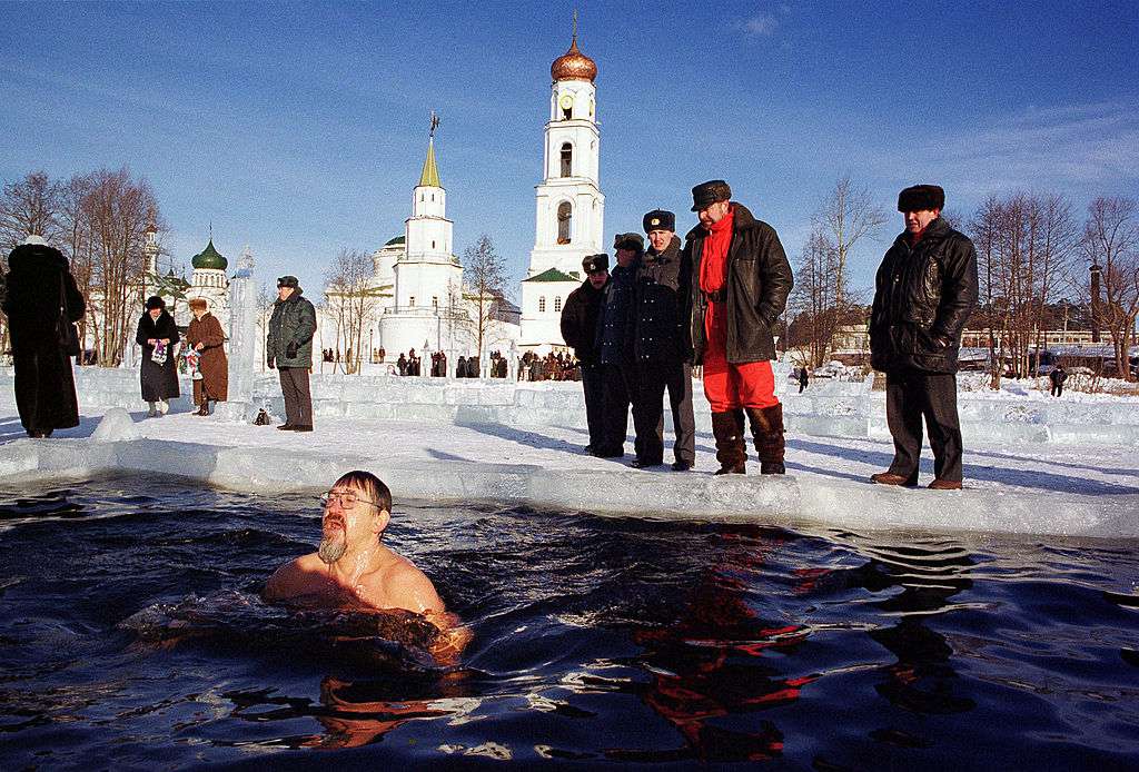 一名俄罗斯男子在冰水中洗澡，其他人则在祈祷，纪念俄罗斯东正教主显节