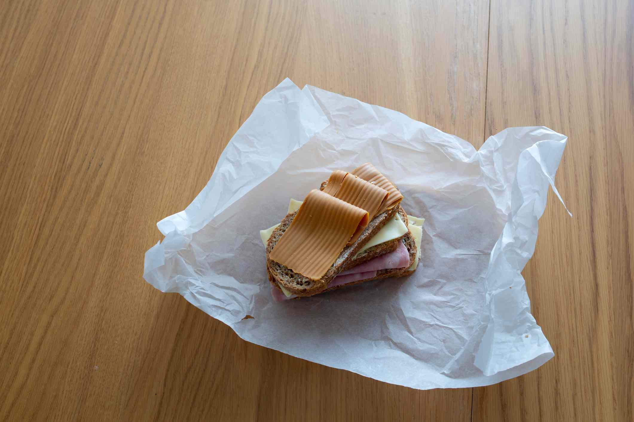 用食品包装纸包装的三明治。“width=
