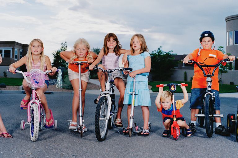 孩子们骑着滑板车和自行车