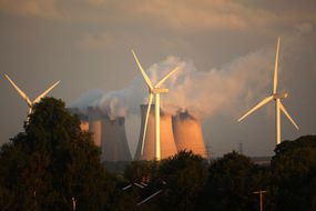 风力涡轮机矗立在欧洲最大的燃煤发电站旁＂width=