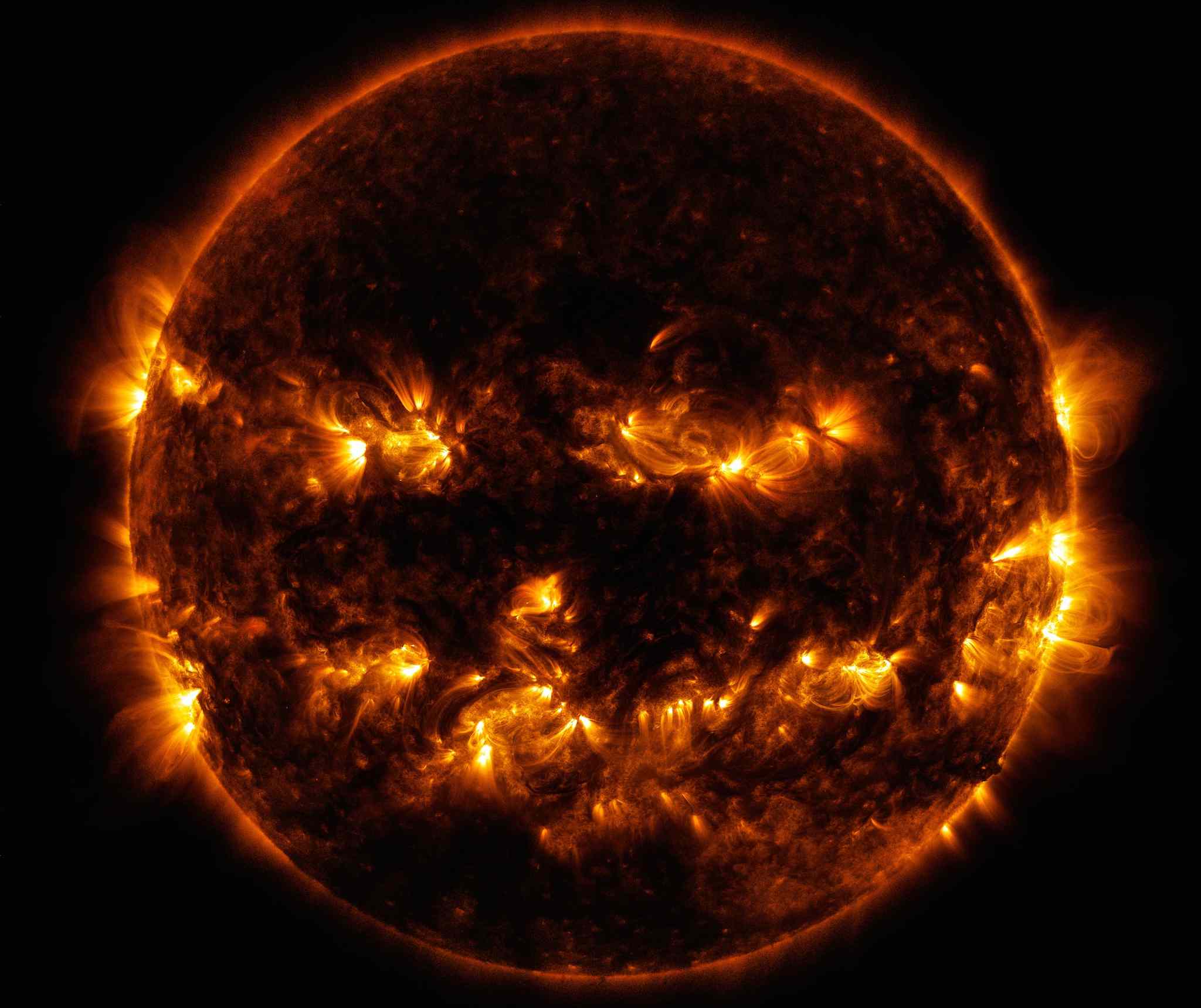 从太空拍摄的太阳特写照片，周围的火焰和中心形成了一个类似微笑的脸