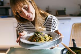 女人拿着一碗素食意大利面