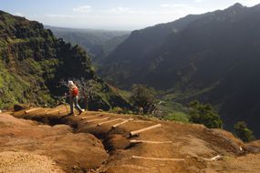 一名徒步旅行者在夏威夷考艾岛的威美亚峡谷下行时＂width=