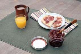 一罐罐头蜜饯或果酱是打开的早餐与吐司和果汁