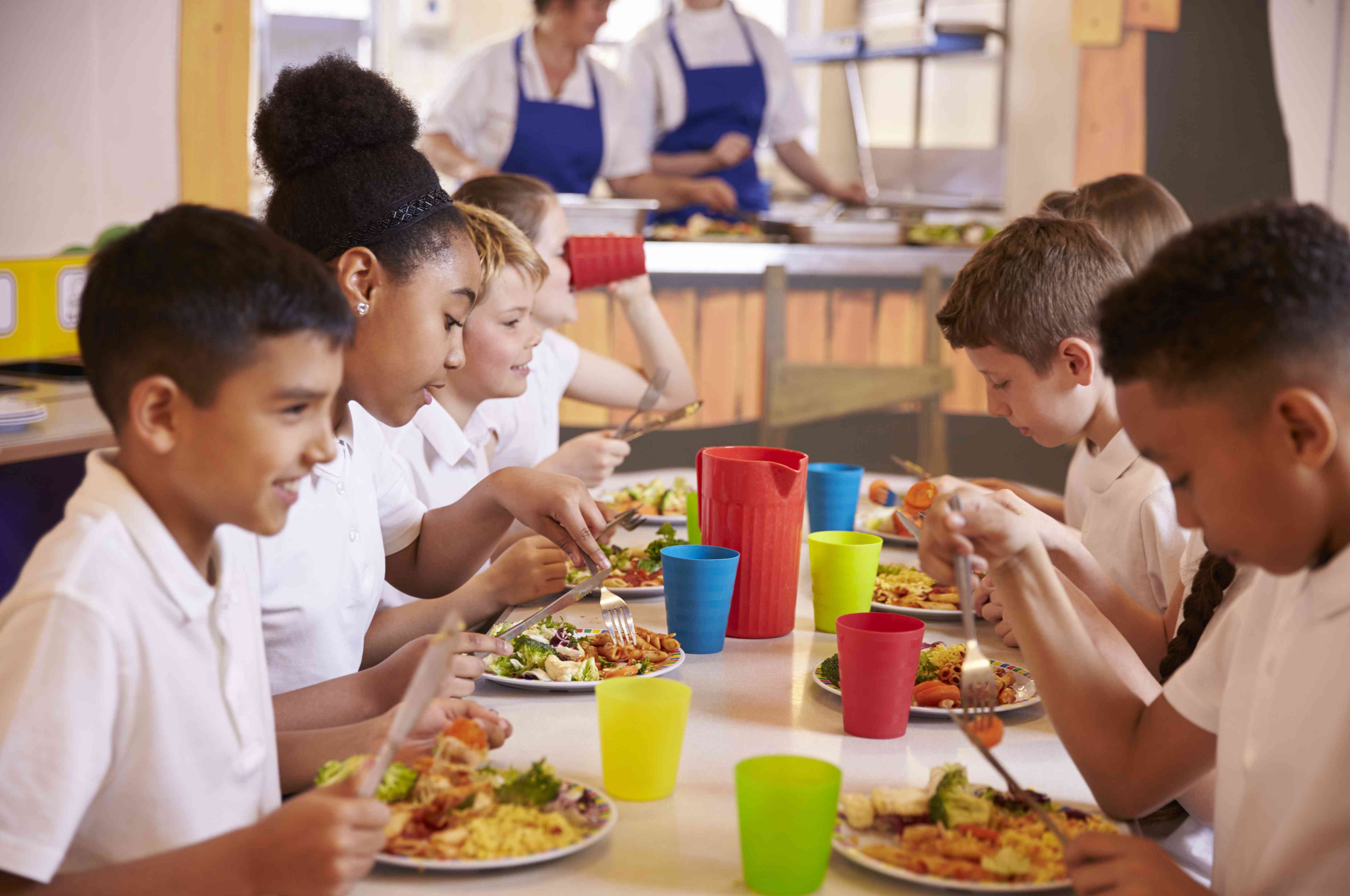 群孩子在餐桌上吃学校午餐