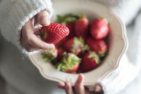 女人手拿古董碗甜草莓