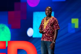 威廉·坎坎瓦巴（William Kamkwamba）在舞台上讲话。“width=