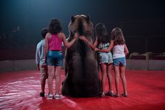 格兰假日马戏团的棕熊蒂玛摆姿势与孩子们合影