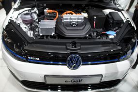 开放的引擎盖揭示了大众电子高尔夫电动汽车的电动机。“width=