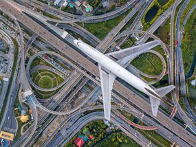 俯视飞机飞过公路路口。交叉高速公路立交桥东外环曼谷，泰国。