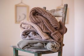 舒适的矮胖毛衣中的毛衣堆积在木椅上