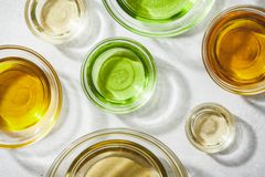 各种油(castor、橄榄油、杏仁、椰子)与光反射在玻璃碗