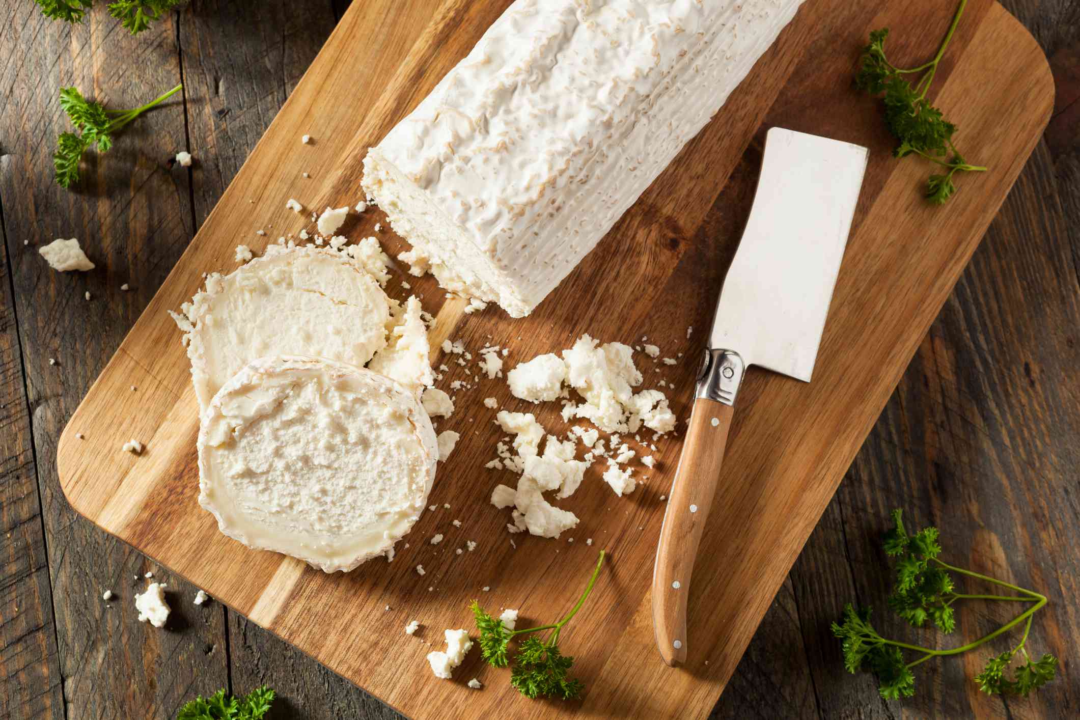 用刀把山羊奶酪放在切菜板上。