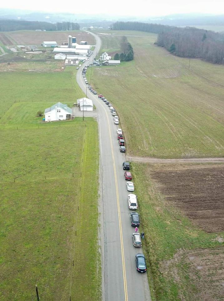 汽车在乡村高速公路上排队，等待从乳品公司购买牛奶