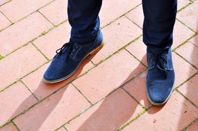 蓝色绒面革男人的鞋子在木板路上