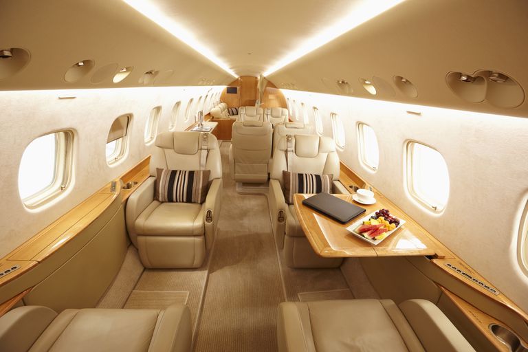 一架昂贵私人飞机的内部配有真皮座椅和水果托盘